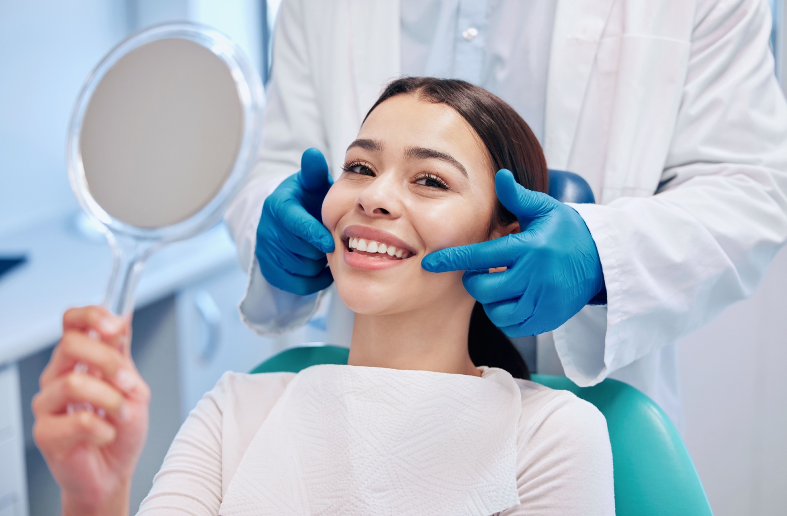 A person smiling as a dentist points their mouth